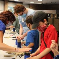 A teacher helps a student work on his project